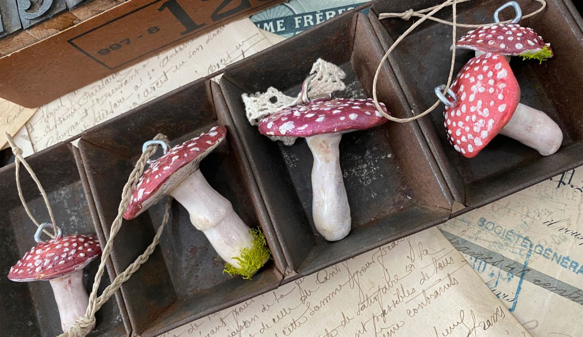 Row of clay mushroom ornaments with red caps.
